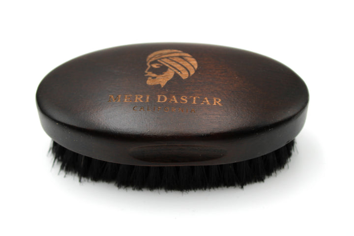 Black hairbrush with wooden handle and 'Meri Dastar' branding on a white background