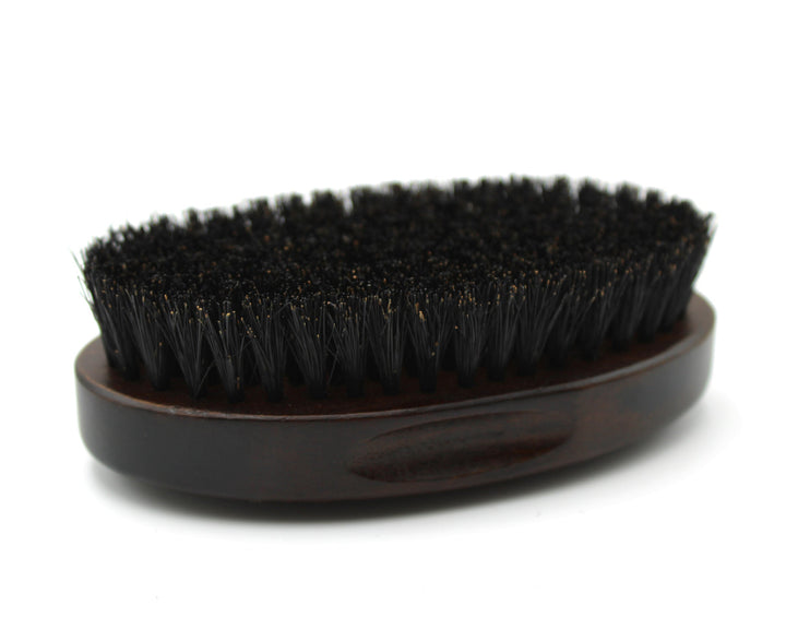 Black bristle brush on a wooden handle against a white background