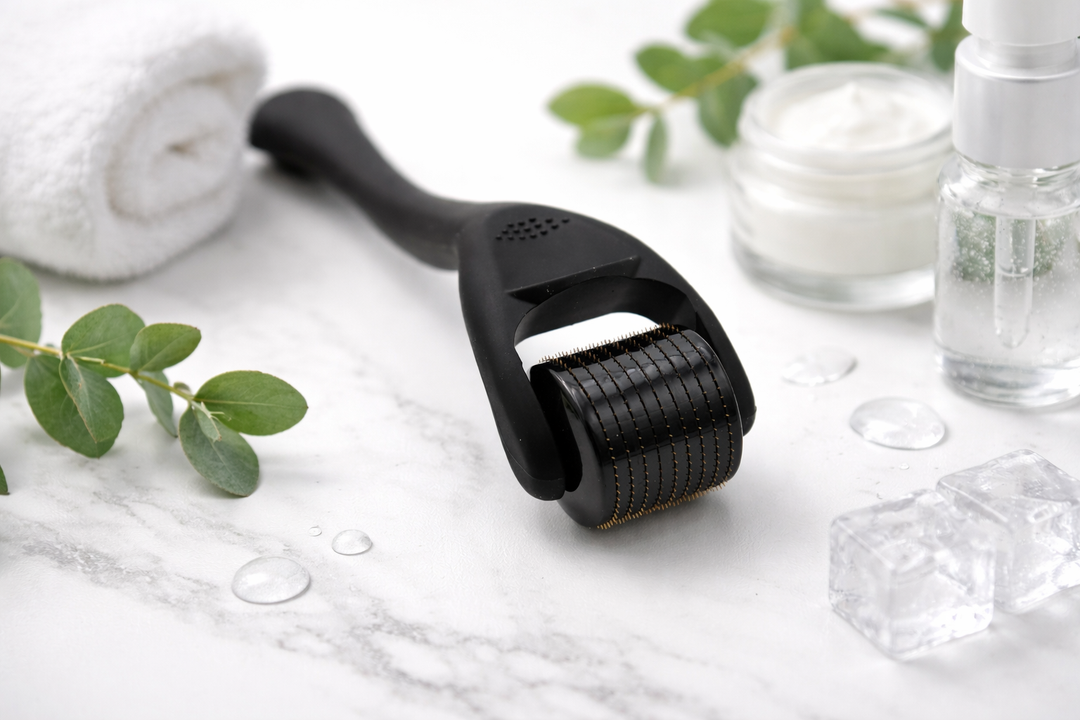 Black derma roller tool with roller head and handle on a white background